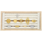 Display nero per anelli in legno con diversi anelli su sfondo beige