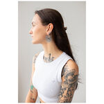 Mujer con pendientes Daisy Hoops en negro y plata sobre fondo gris