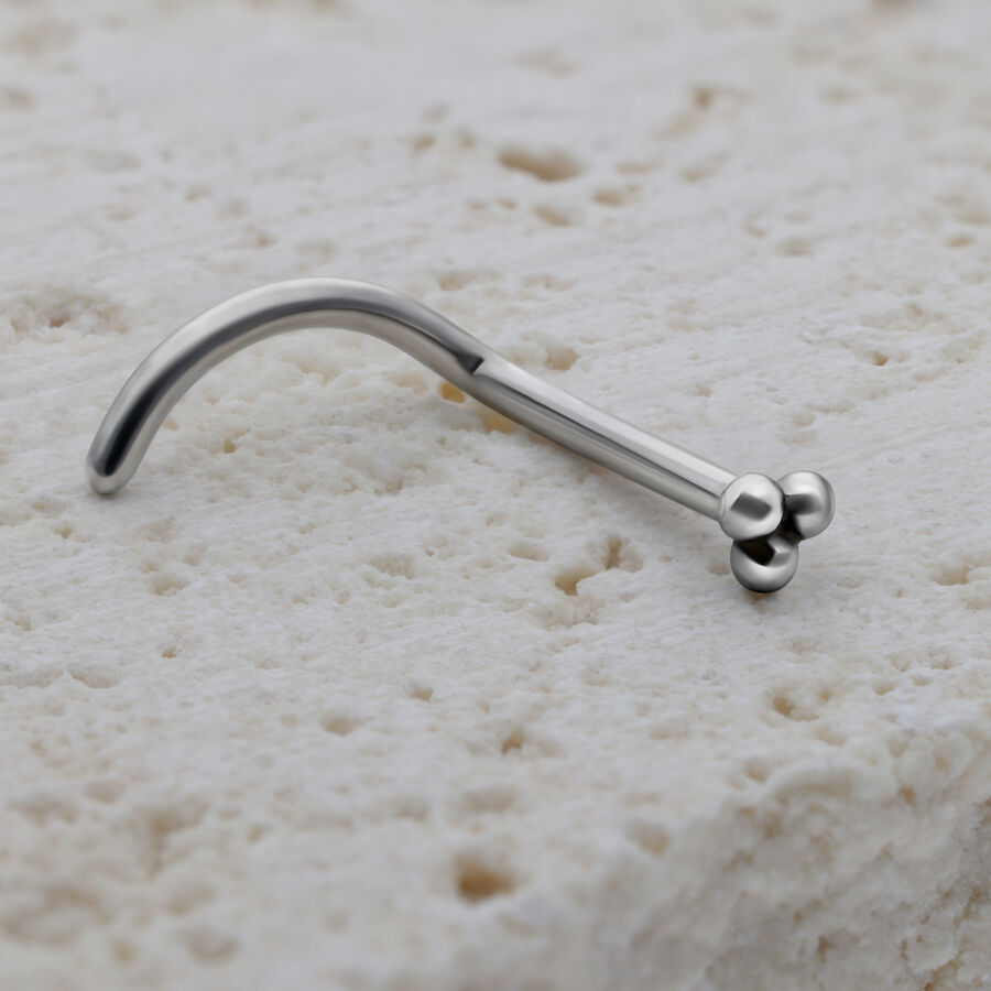 Piercing nasal plateado de acero quirúrgico sobre piedra clara