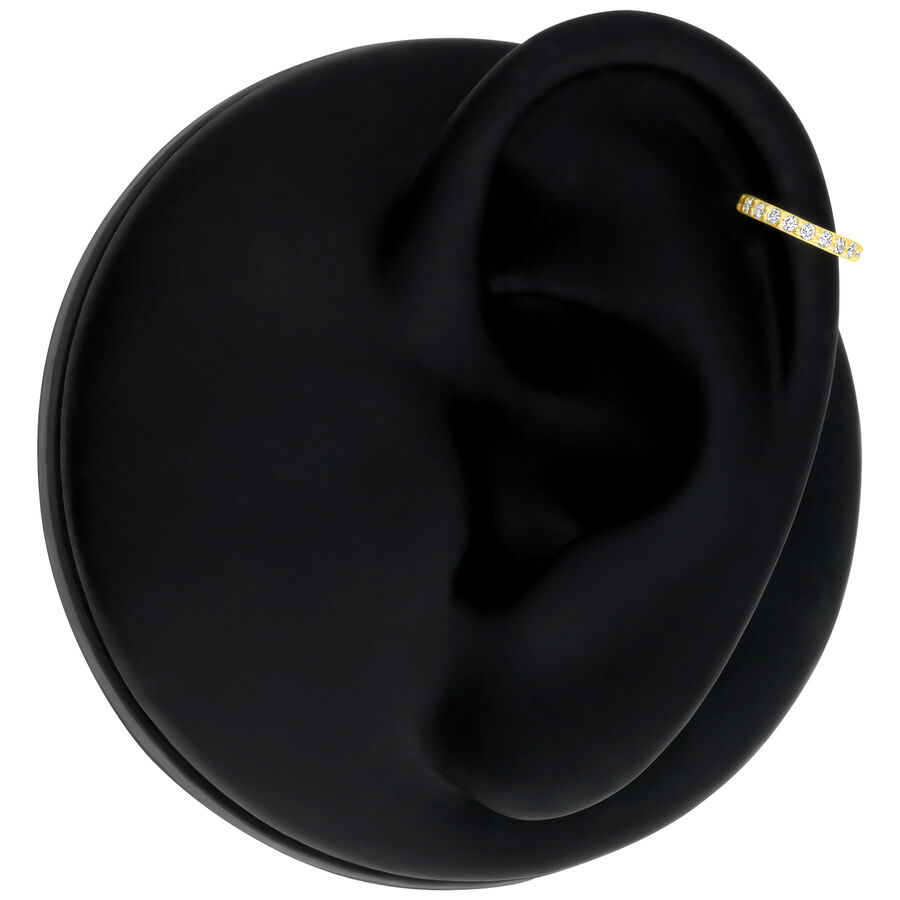 Anello d'oro con diamanti su modello di orecchio nero su sfondo bianco