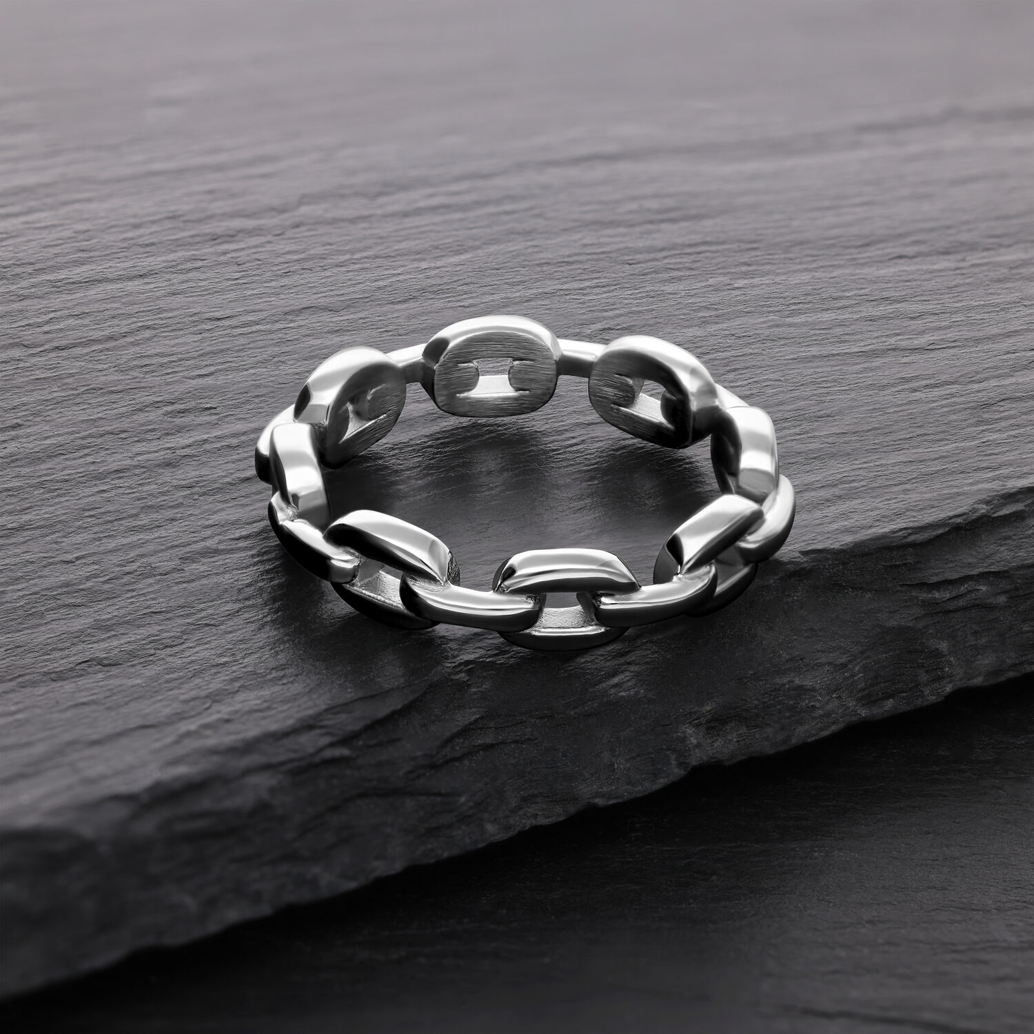 Silberner Link Chain Ring aus Chirurgenstahl Silberner Link Chain Ring aus Chirurgenstahl auf dunklem Stein
