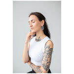 Donna con braccio tatuato indossa orecchini Floral Nautilus Hoops in argento su sfondo grigio