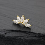 Attacco dorato con pietre di moissanite chiare su sfondo scuro