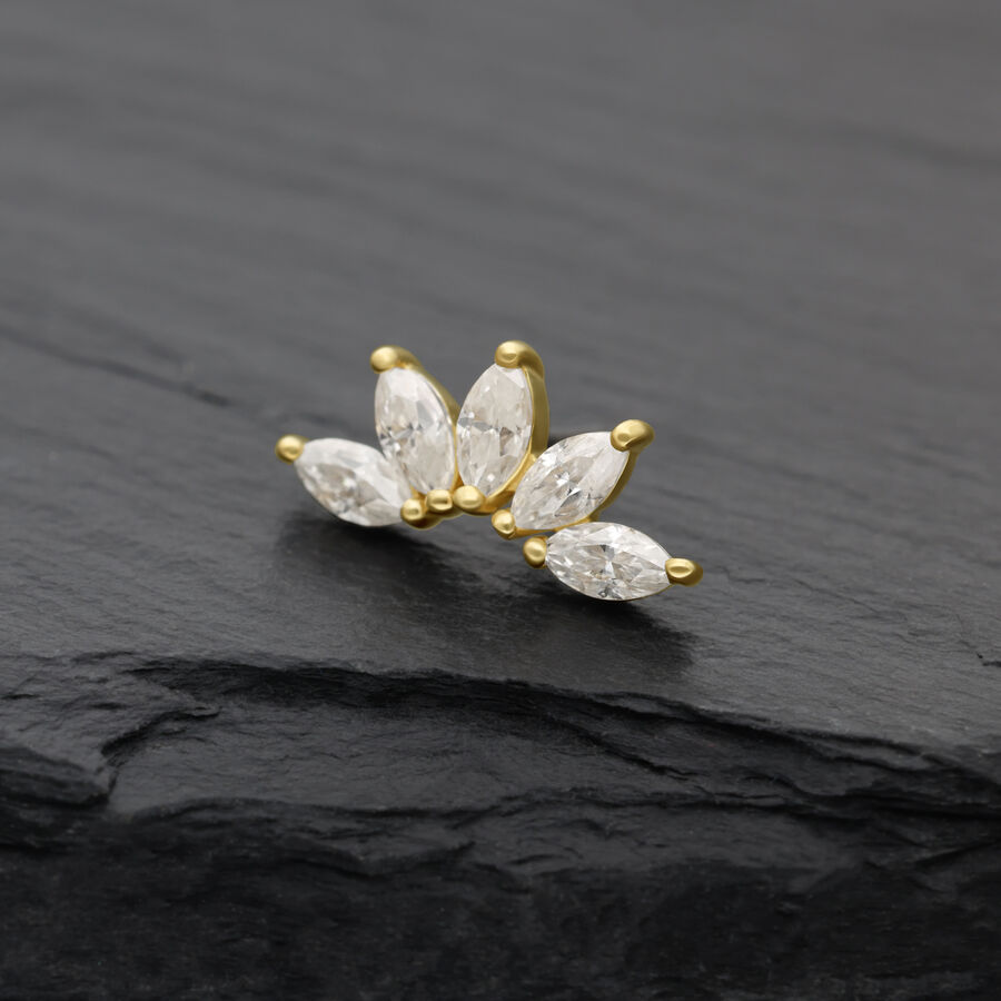 Attacco dorato con pietre di moissanite chiare su sfondo scuro