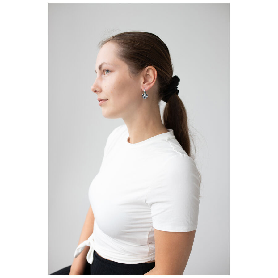 Mujer con aros Little Soulmate en plata, camiseta blanca, perfil lateral