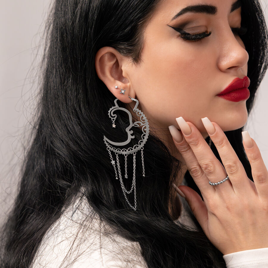 Mujer con aros Sun Moon plateados, perfil lateral, fondo liso