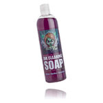 Sapone detergente viola in bottiglia trasparente con etichetta su sfondo bianco
