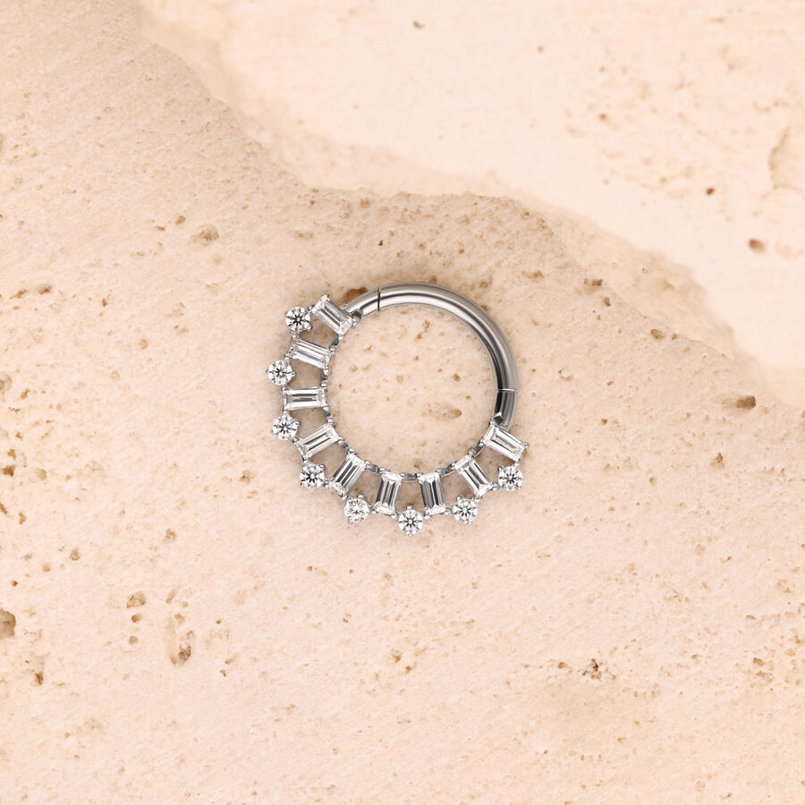Anello piercing in argento con cristalli su superficie di pietra chiara