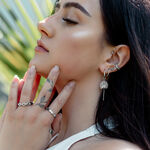 Donna con diversi orecchini, tra cui Little Petticoat Hoops, all'orecchio, all'aperto