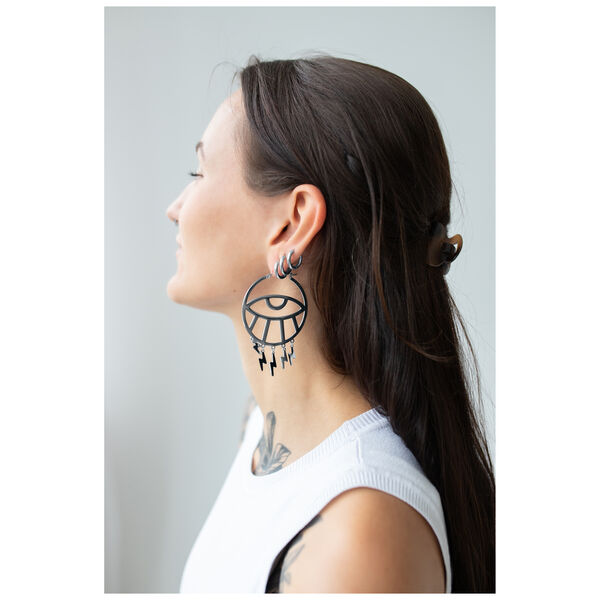 Mujer con cabello largo lleva grandes pendientes Thunderflash Eye Hoops negros de lado