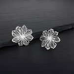 Zwei silberne Blumen Ohrstecker aus Edelstahl auf dunklem Hintergrund