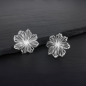 Zwei silberne Blumen Ohrstecker aus Edelstahl auf dunklem Hintergrund
