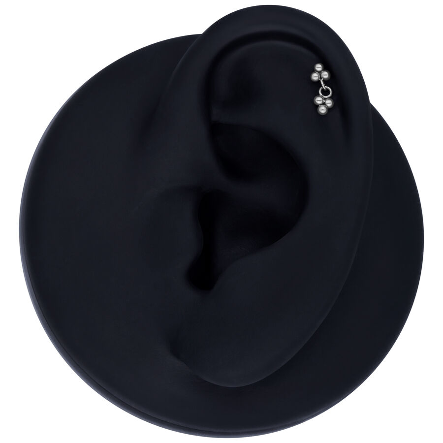 Argento Push Fit Trinity pendente su modello di orecchio nero su sfondo grigio