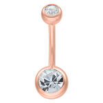 Piercing all'ombelico in oro rosa con due cristalli chiari su sfondo bianco