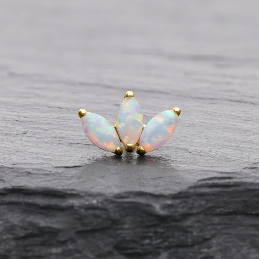 Lotusförmiger Goldaufsatz mit synthetischem Opal auf dunklem Hintergrund