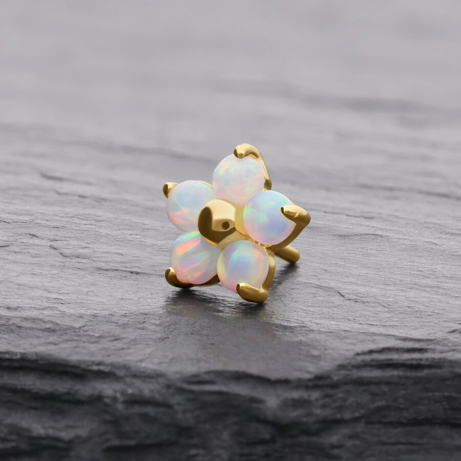Goldener Blume-Aufsatz mit synthetischem Opal auf grauem Hintergrund