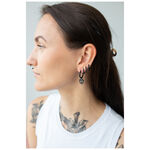 Donna con orecchini Little Skull Hoops neri in acciaio chirurgico