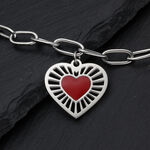 Bracciale color argento con ciondolo a cuore rosso su sfondo scuro