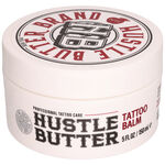 Runde weiße Dose Hustle Butter Deluxe Tattoo Balm mit roter und schwarzer Schrift
