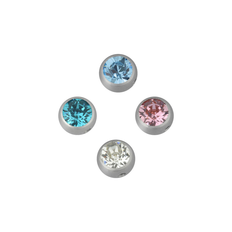 Cuatro accesorios de piercing plateados con cristales en azul, rosa y cristal claro sobre fondo blanco