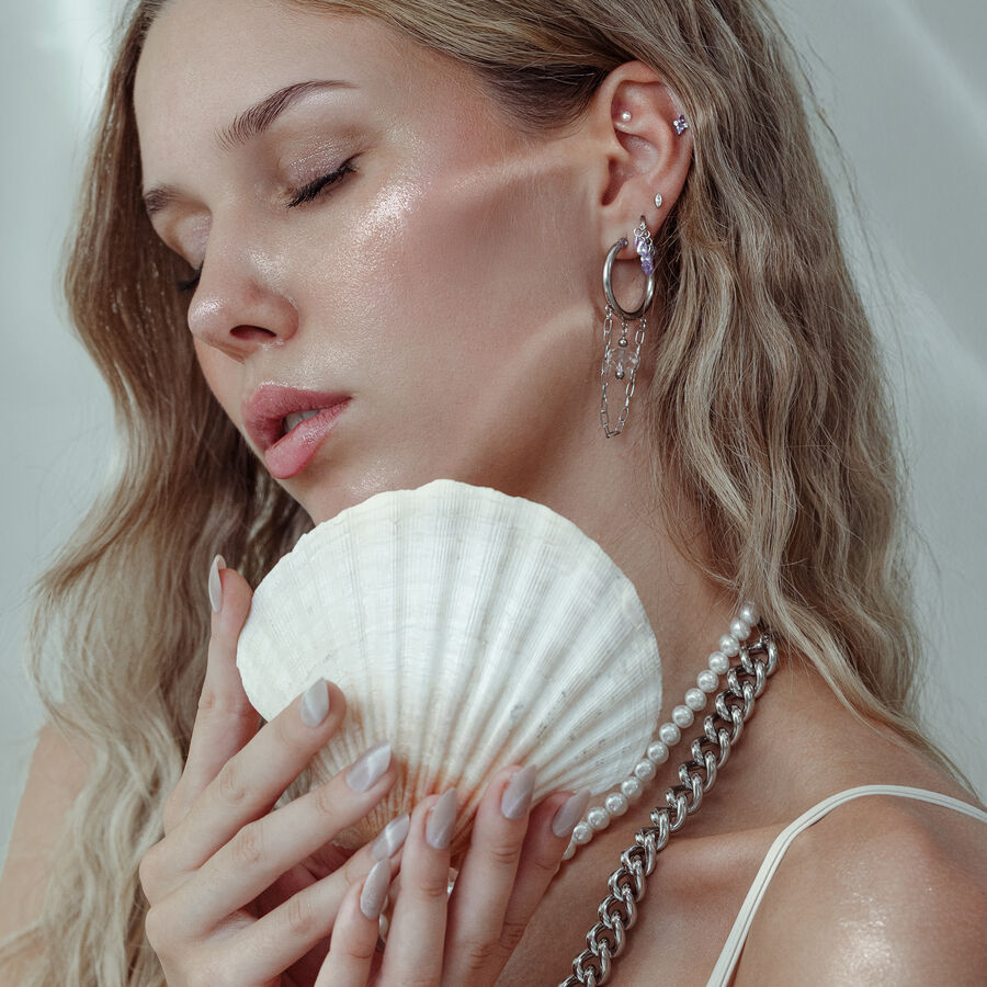 Frau mit Piercing-Aufsatz und Muschel, Ohrringe aus Silber und Gold