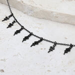 Pulsera Snake negra con cierre ajustable sobre piedra clara