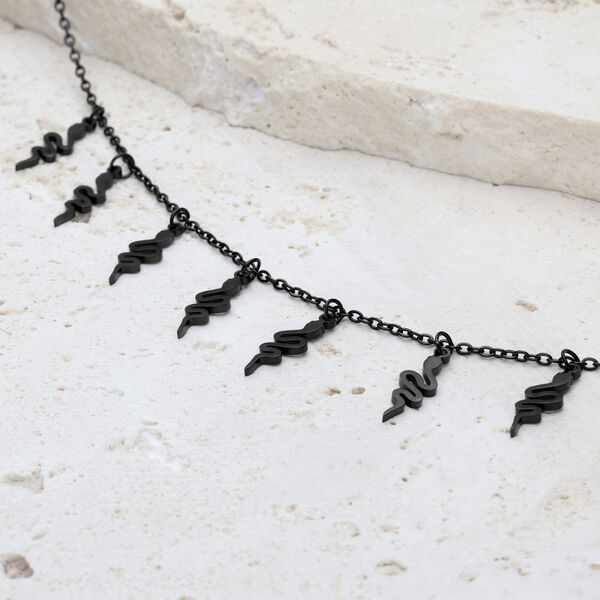 Pulsera Snake negra con cierre ajustable sobre piedra clara