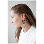 Mujer con cabello largo lleva pendientes La Fleur Hoops en negro y plata