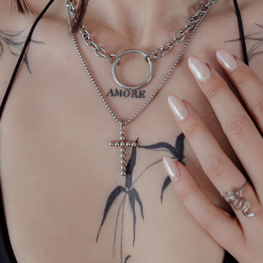 Collana Bubble Cross in argento su una donna con tatuaggi, primo piano