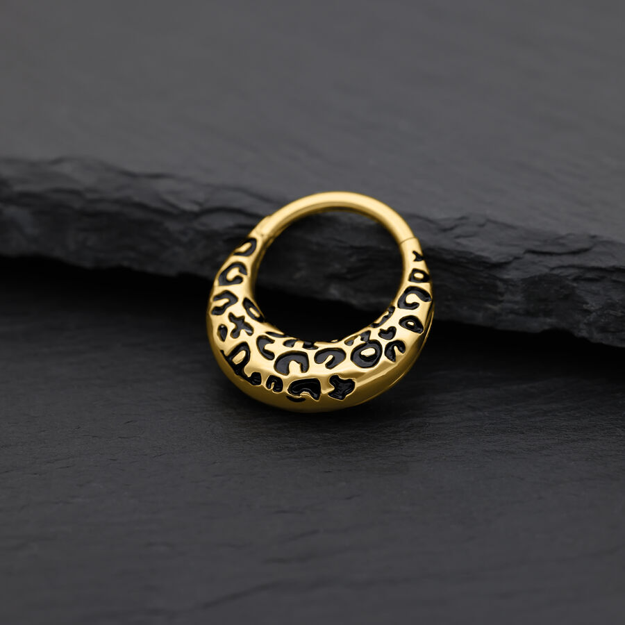 Clicker de septum dorado con estampado de leopardo sobre fondo negro