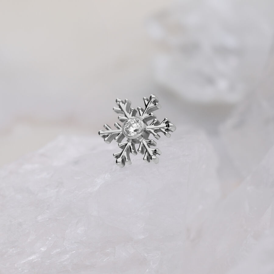 Punta piercing a fiocco di neve argentata con cristallo trasparente su sfondo bianco