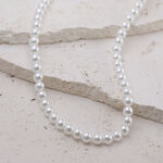 Collana di perle in argento in acciaio chirurgico su sfondo chiaro
