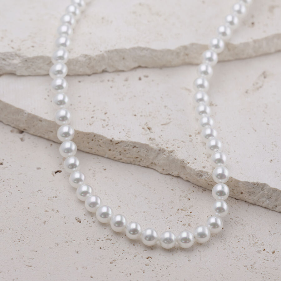 Collana di perle in argento in acciaio chirurgico su sfondo chiaro