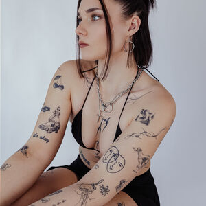 Goldene O Halskette aus Chirurgenstahl Frau mit goldener O Halskette aus Chirurgenstahl, Tattoos sichtbar