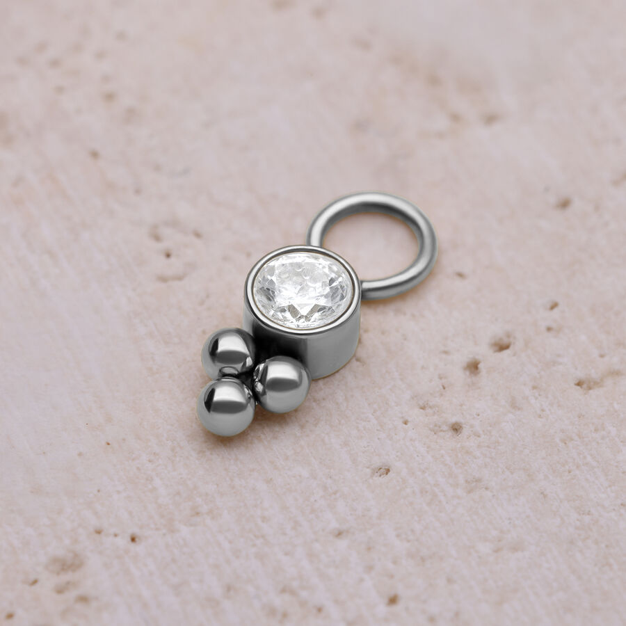 Ciondolo piercing argento con cristallo e sfere su sfondo chiaro