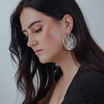 Orecchini Noble Leaf Hoops in argento su donna con capelli lunghi e scuri