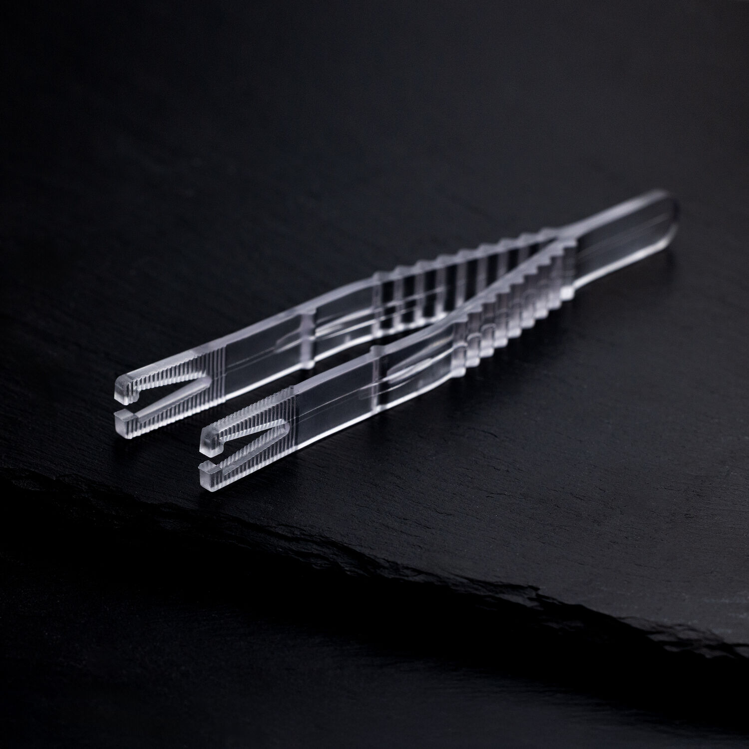 Sterile Triangel Piercingzange auf schwarzem Hintergrund Klare sterile Triangel Piercingzange auf schwarzem Hintergrund, einzeln verpackt