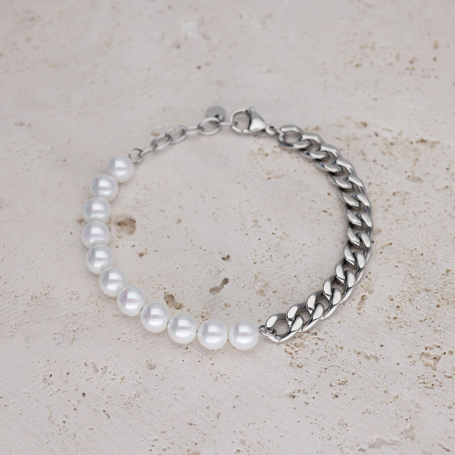 Bracciale con perle bianche e catena argentata su pietra chiara