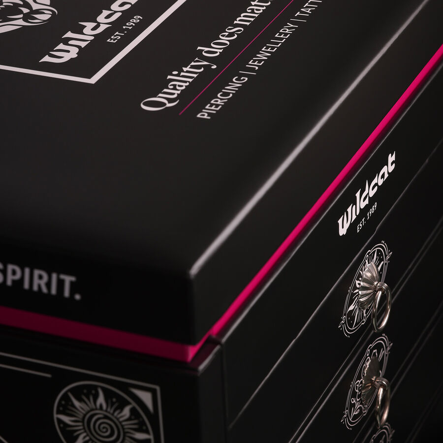 Scatola nera per gioielli con logo Wildcat e bordo rosa, fotografata di lato