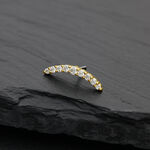 Accessorio ad arco dorato con cristalli di moissanite chiari su sfondo nero