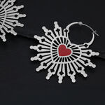 Aros plateados en forma de corazón con corazón rojo sobre fondo oscuro