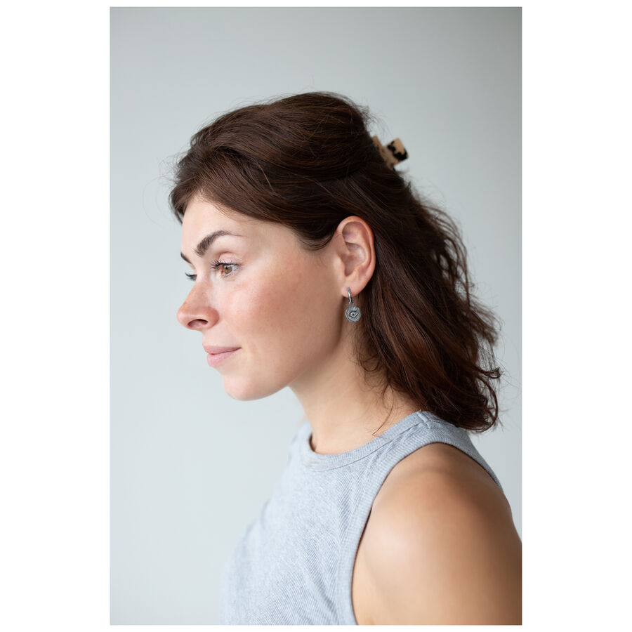 Mujer con cabello castaño lleva Little Luminous Eye Hoops, vista lateral