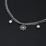 Bracciale in argento su sfondo nero con ciondoli floreali e cristalli