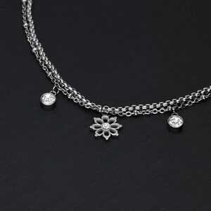 Little Floralis Armband in Silber mit Kristall Silbernes Armband auf schwarzem Hintergrund mit floralen Anhängern und Kristallen