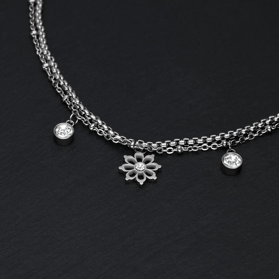 Bracciale in argento su sfondo nero con ciondoli floreali e cristalli