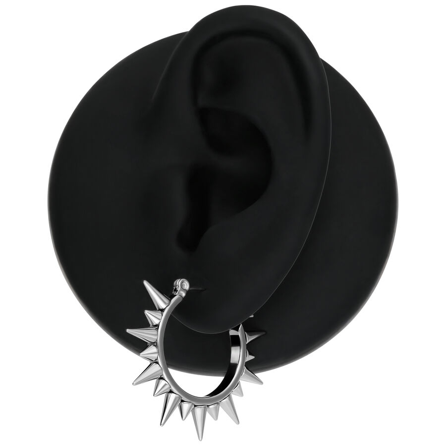 Pendientes Spiked de plata en un modelo de oreja negra sobre fondo blanco