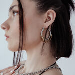 Donna con eleganti hoops massicci con loops in argento e oro su sfondo bianco