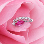 Ajuste de plata con cristal rojo ovalado sobre pétalo rosa