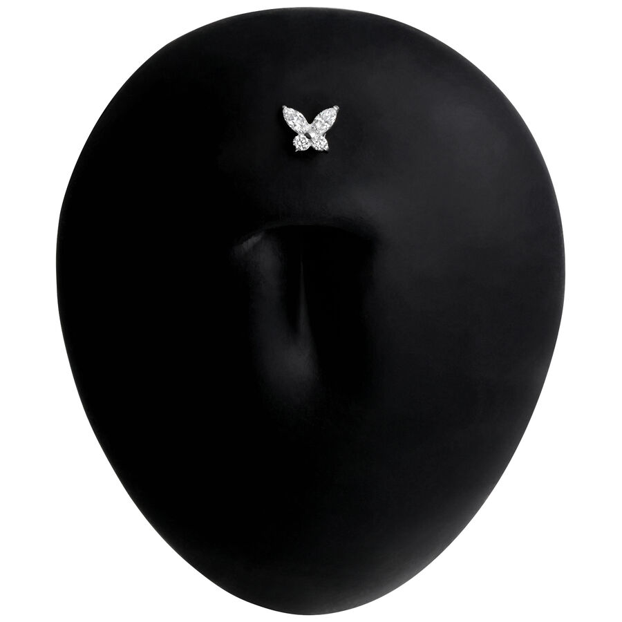 Schwarzes Titan Labret Piercing mit Schmetterlingsmotiv auf schwarzem Hintergrund