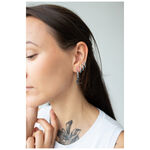 Donna con Little Moonchild Hoops neri, indossati lateralmente all'orecchio